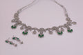 Silver necklace with green gemstones on a white background