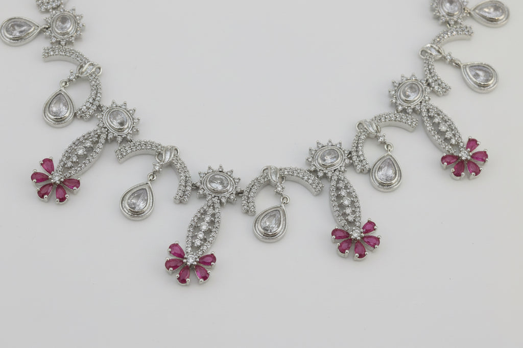 Silver necklace with pink gemstones on a white background