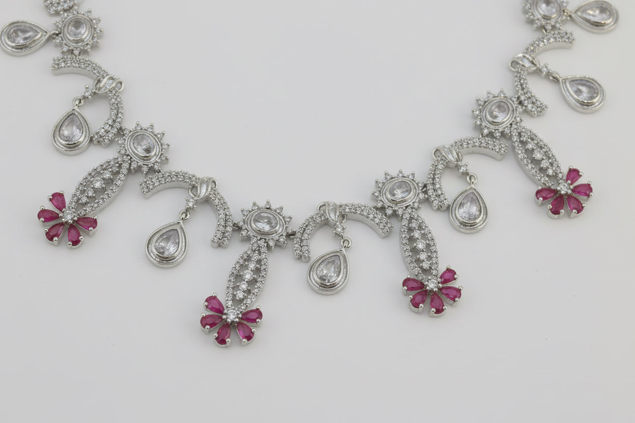 Silver necklace with pink gemstones on a white background